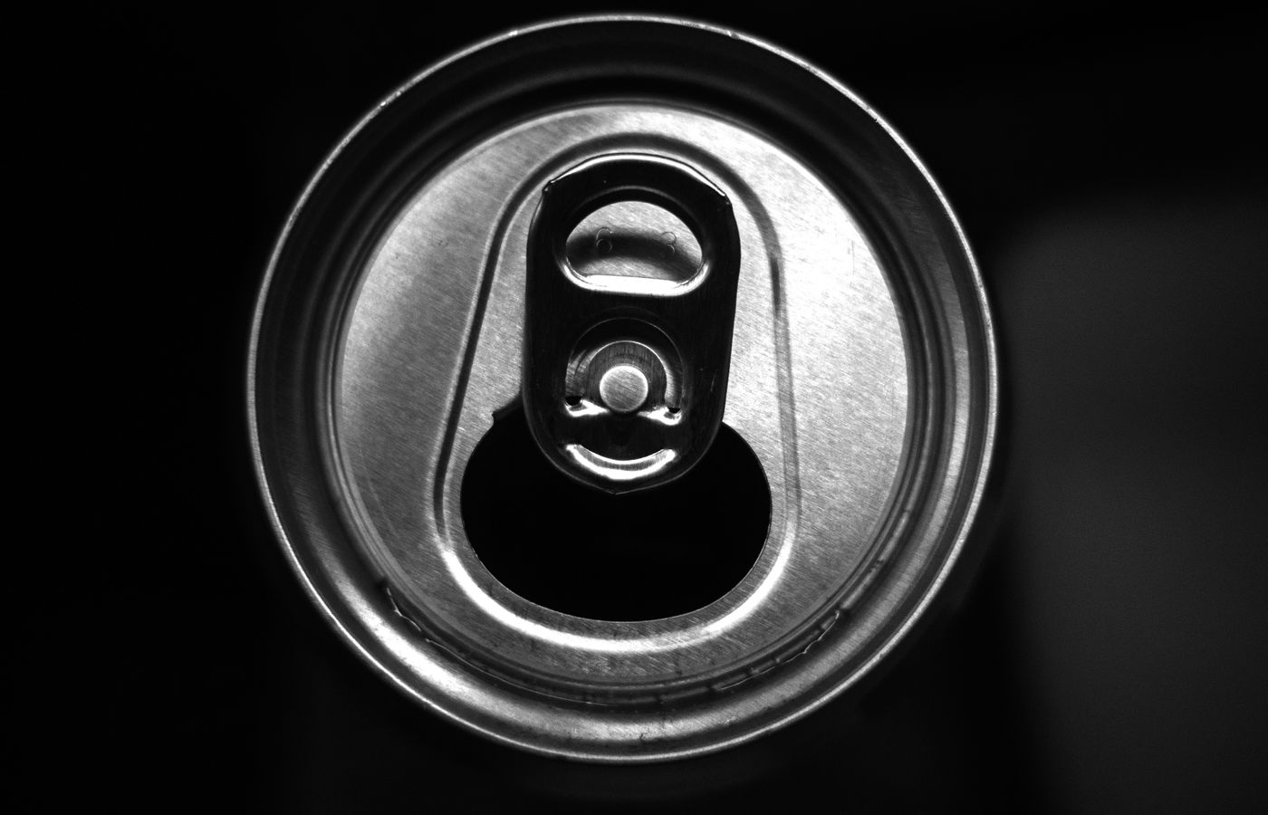 High contrast image of an opened beverage can, focus on metal texture.