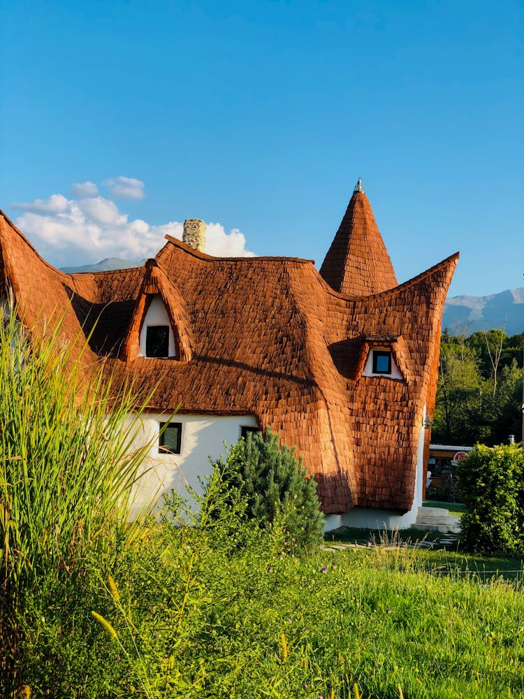 Brown And White Concrete House On Green Grass Field