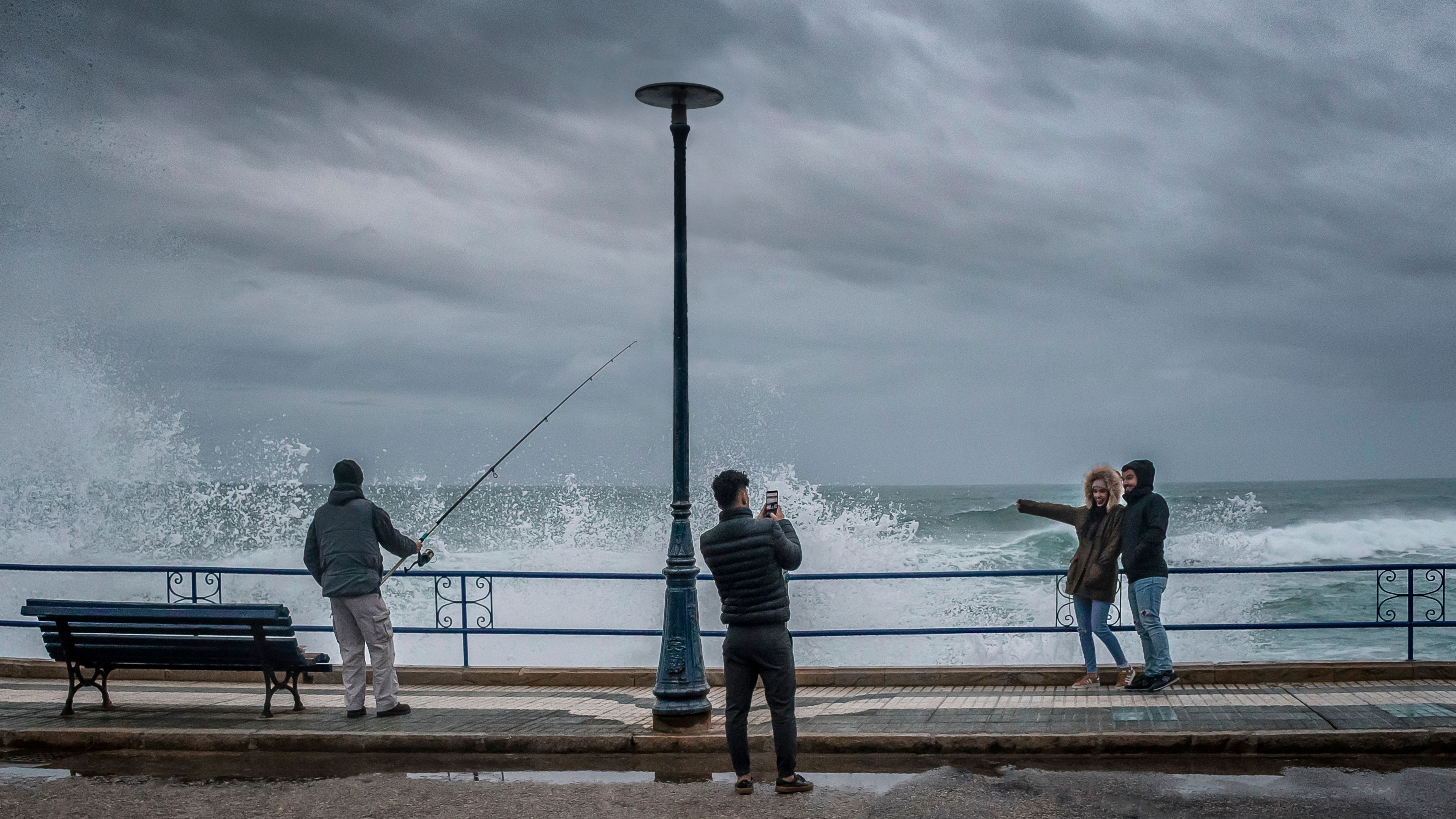 People Standing beside Metal Railing near Body of Water · Free Stock Photo