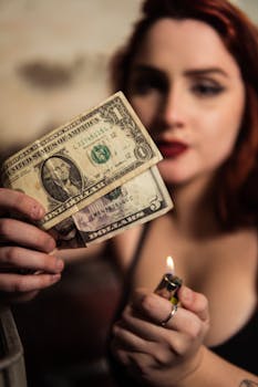 A woman holding dollar bills with a lighter, hinting at risk or finance themes.
