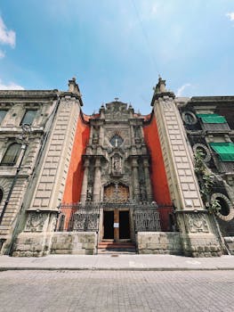 Stunning low angle view of a Baroque architecture church facade in Mexico City against a clear blue sky.