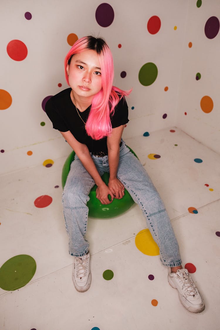 Girl With Pink Hair Posing In Studio With Colorful Dots