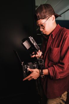 Photographer in Orlando using advanced camera gear, wearing a red shirt and cap.