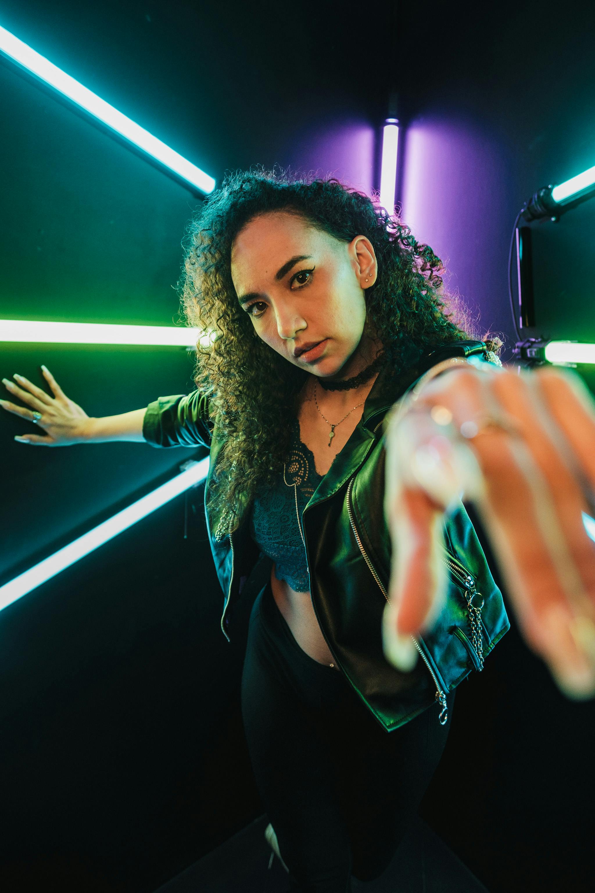 woman posing in dark studio with neon lights