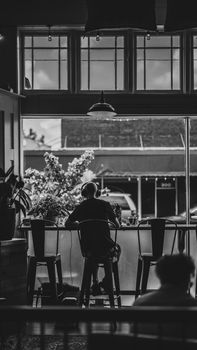 Black and white photo of a person sitting inside a cafe, Little Rock, AR.
