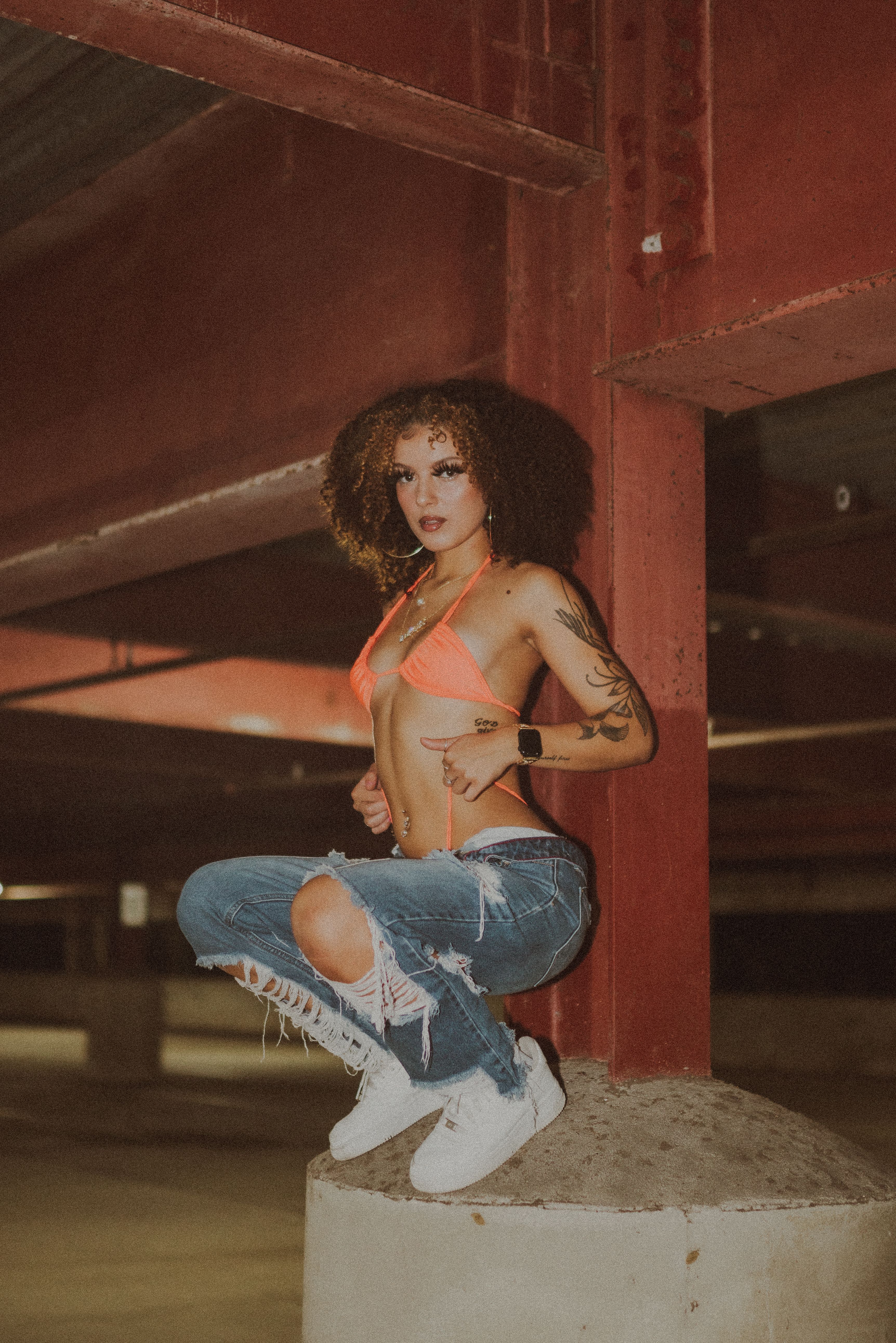 Stylish woman in a bikini and jeans in an Orlando parking garage.