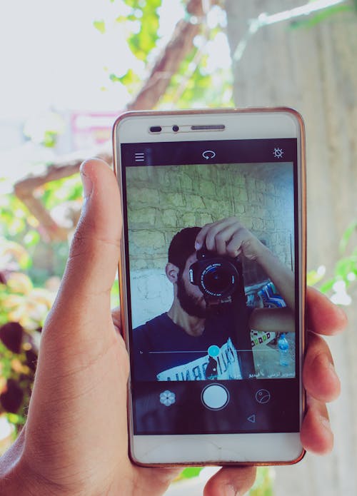 Gratis Orang Yang Memegang Smartphone Android Putih Foto Stok