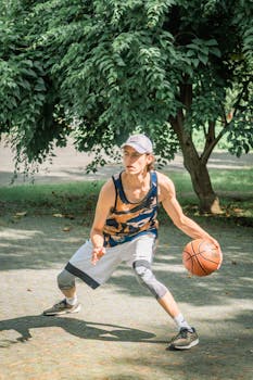 A young man dribbling a basketball outdoors in a sunny park in Ciudad de México, Mexico.