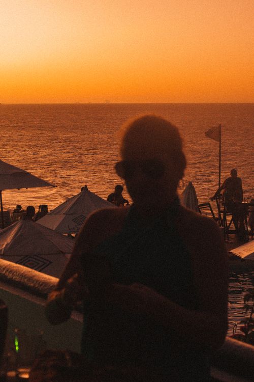 Free A captivating silhouette by the seaside at sunset, bathed in warm, vibrant hues. Stock Photo