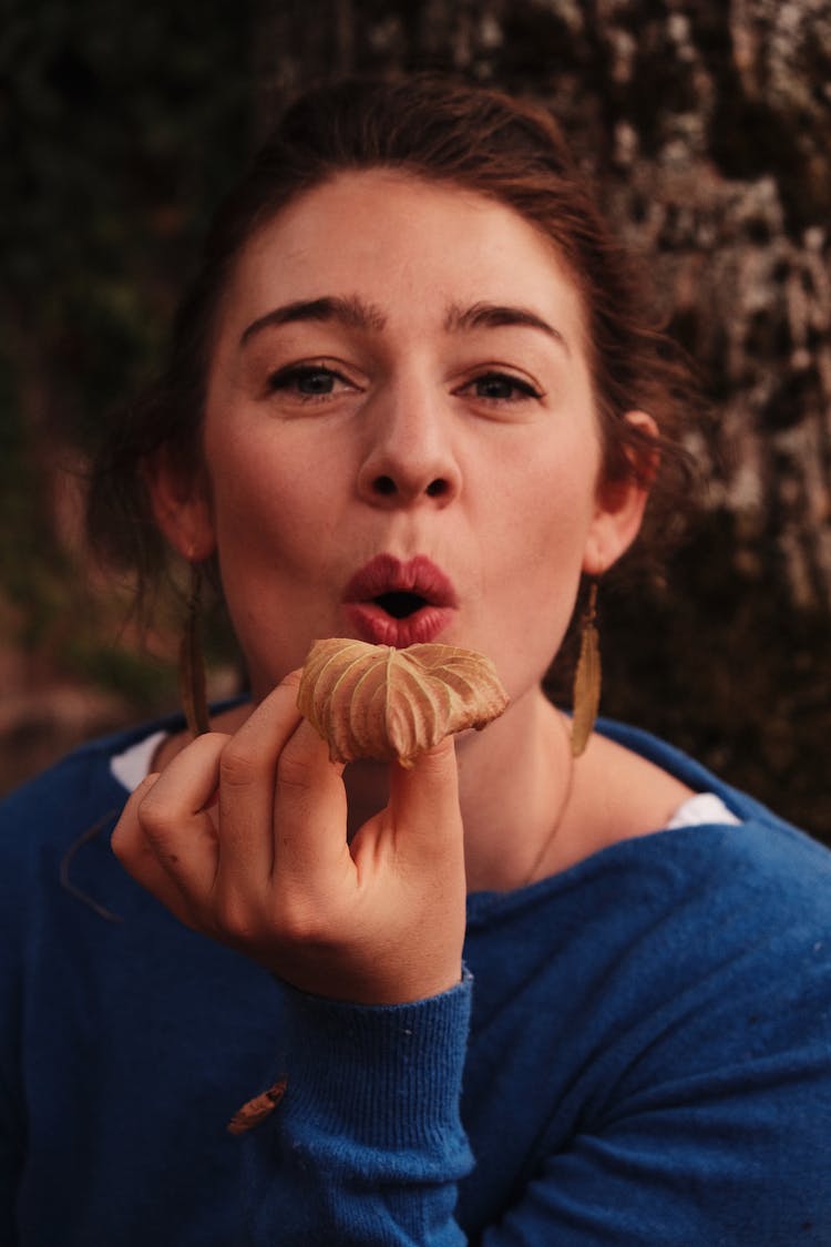 Woman Blowing A Leaf