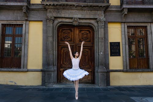 Ballerina in a Red Dress and Ballet Shoes Standing on Tiptoes on a ...