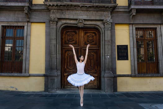 Ballerina in a tutu poses gracefully by a historic door in Mexico City, capturing elegance and architectural beauty.