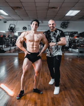Two men posing confidently in a well-lit gym space, showcasing fitness and strength.