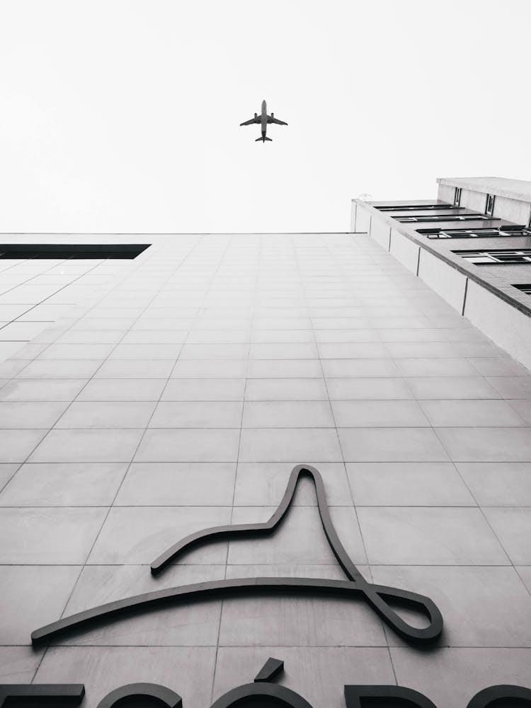 Airplane Flying Over Building