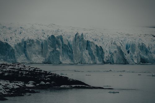 Free Stunning view of a vast frozen glacier landscape during winter, featuring icy formations against a serene lake. Stock Photo