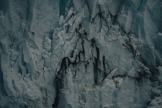 Detailed view of a rugged glacier with cracks and textures, showcasing icy formations.