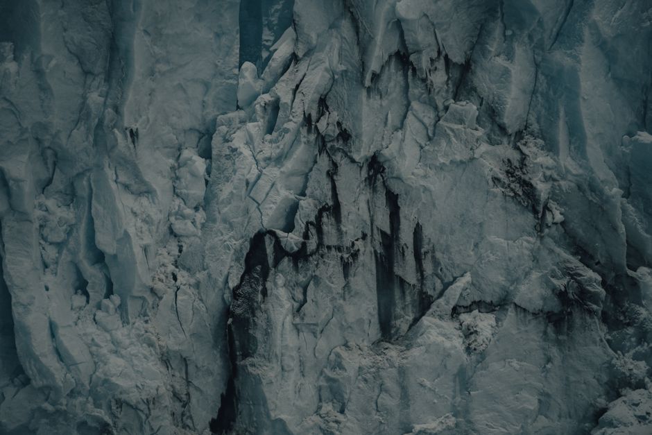 Detailed view of a rugged glacier with cracks and textures, showcasing icy formations.
