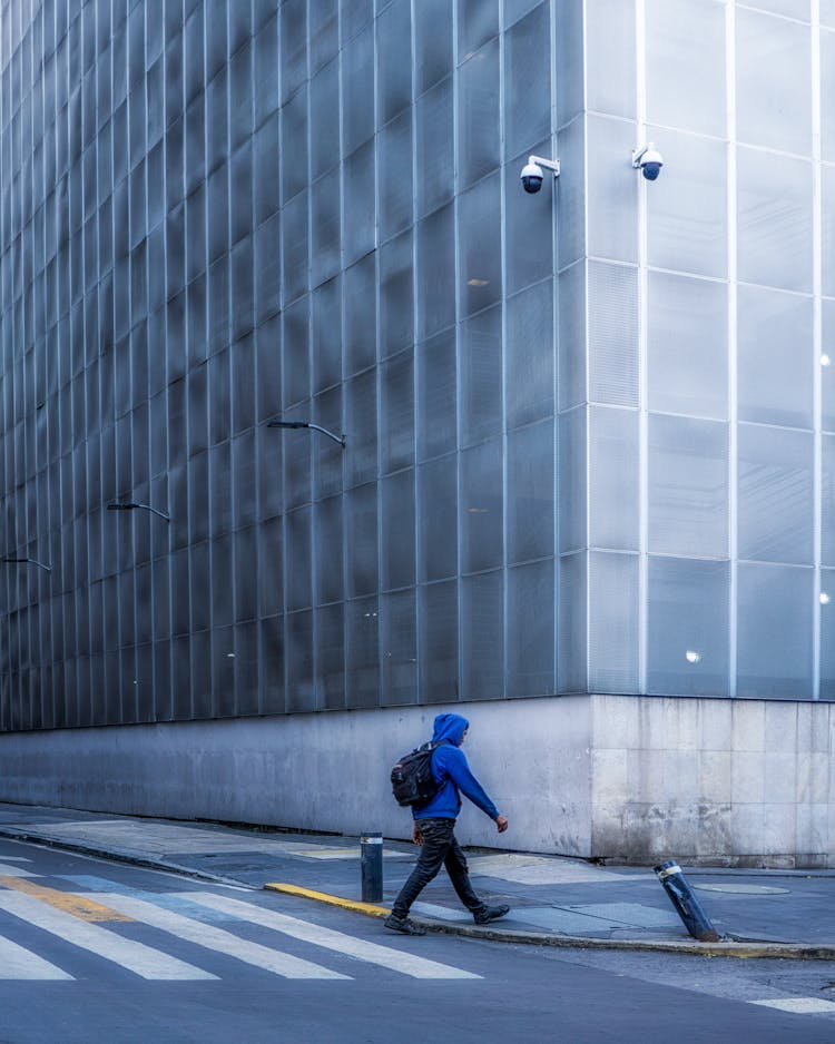 Person Wearing A Blue Hoodie Crossing The Street