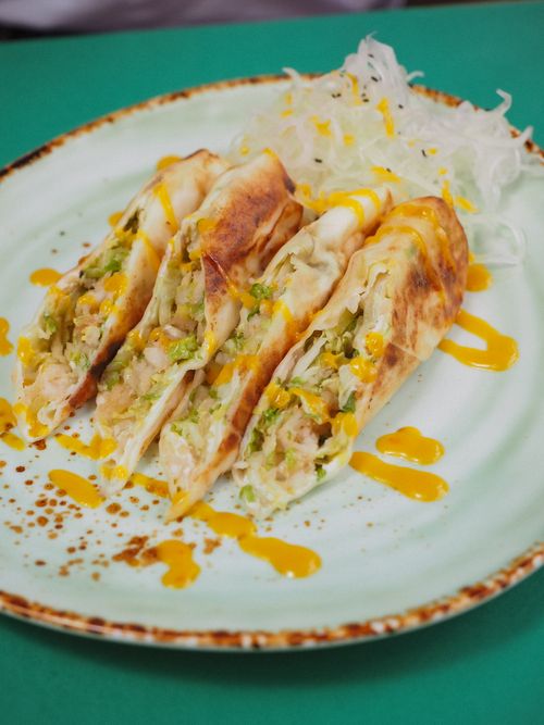 Free Delicious tortilla wraps filled with fresh veggies on ceramic plate. Stock Photo