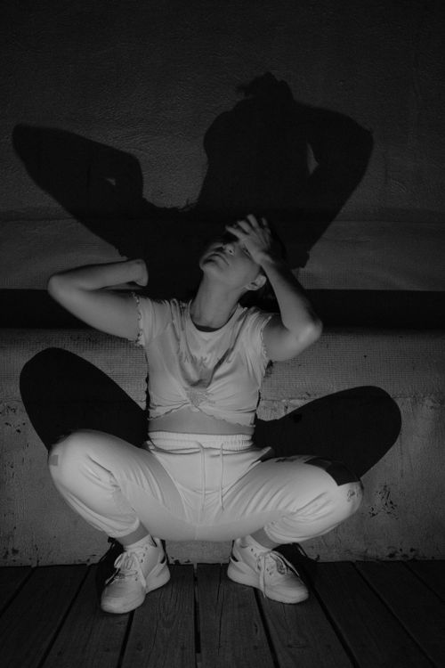 Free Artistic monochrome photo of a woman in expressive pose with dramatic shadow play. Stock Photo
