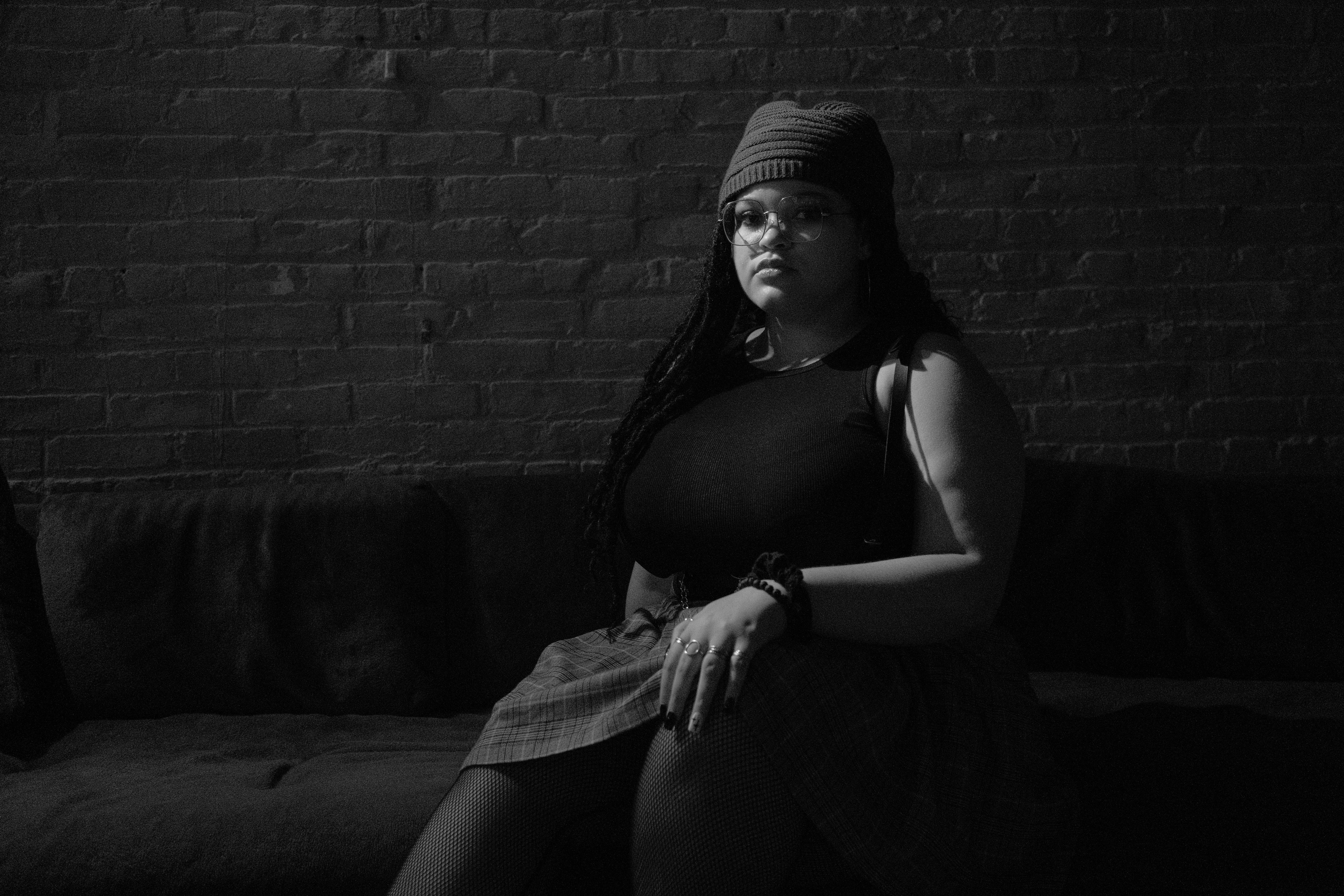 Grayscale Photo of a Woman Sitting on a Couch · Free Stock Photo