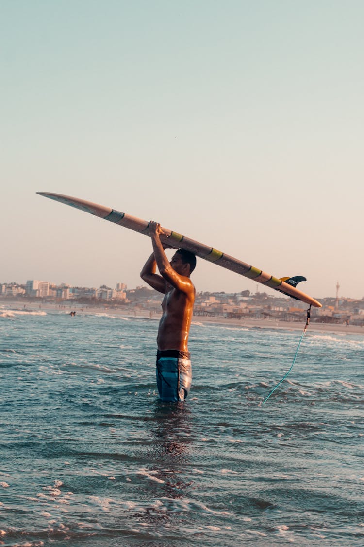 Man With Surfboard Standing In Sea