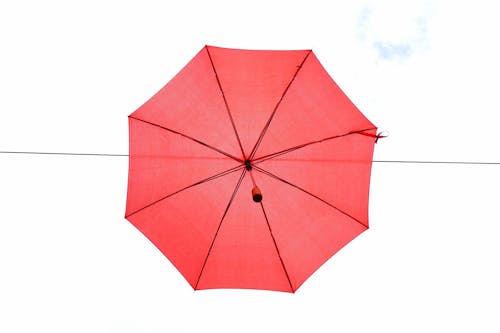 Red Umbrella in Mid Air during Day