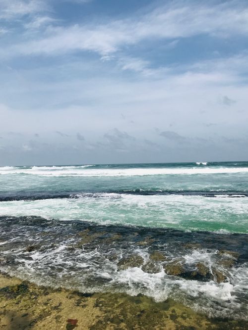 Free Experience the natural beauty of Sri Lanka's coastline with crashing waves and clear skies. Stock Photo
