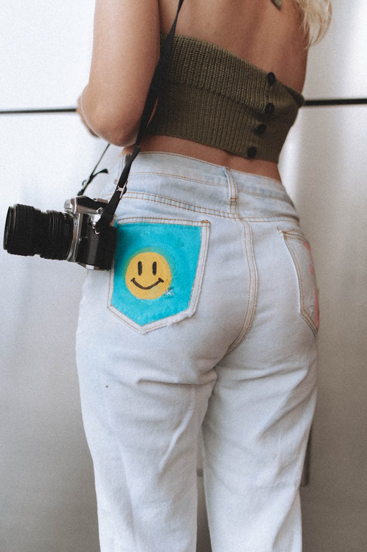 Close-up Of Woman In Jeans With Professional Camera