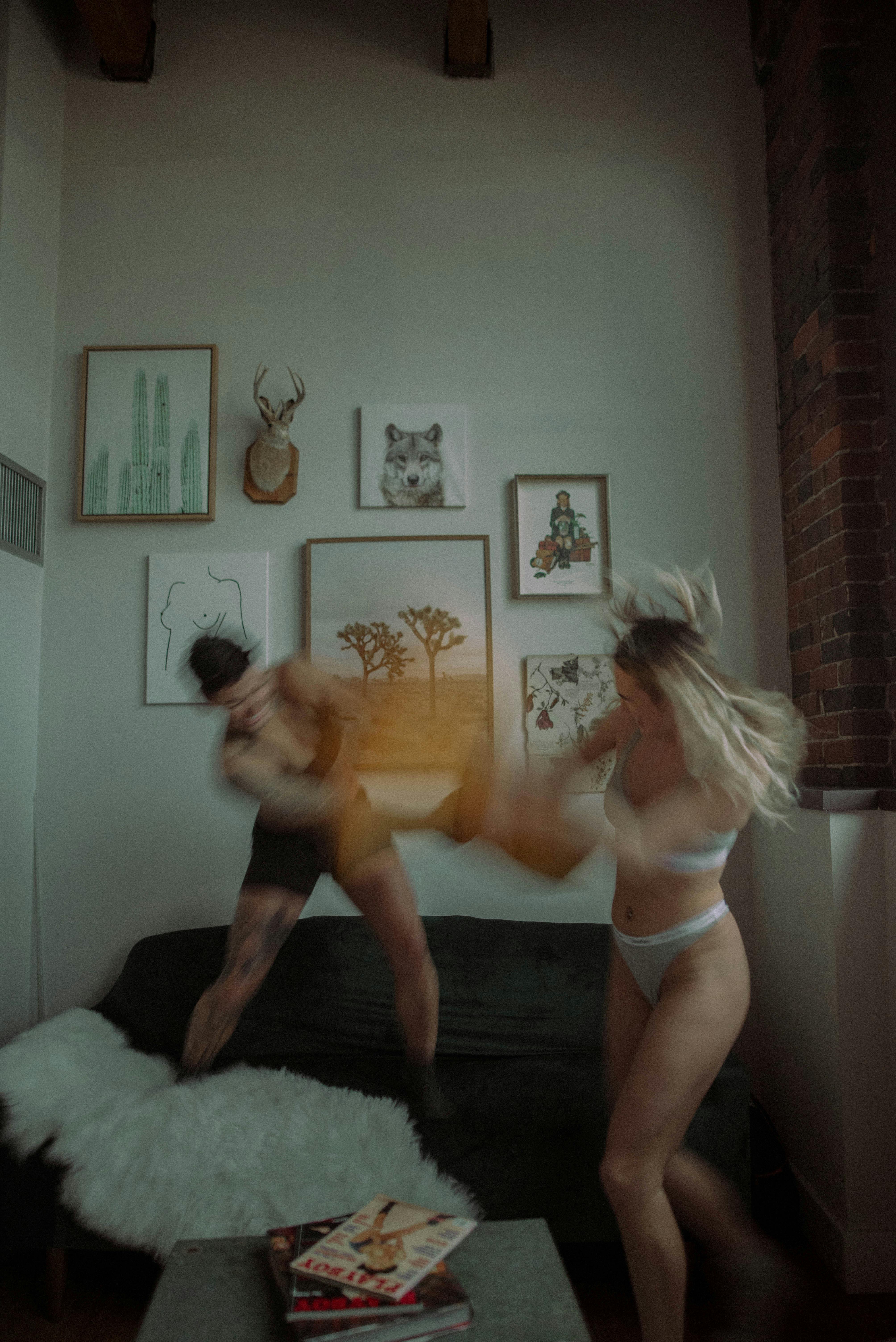 women in lingerie fighting with pillows