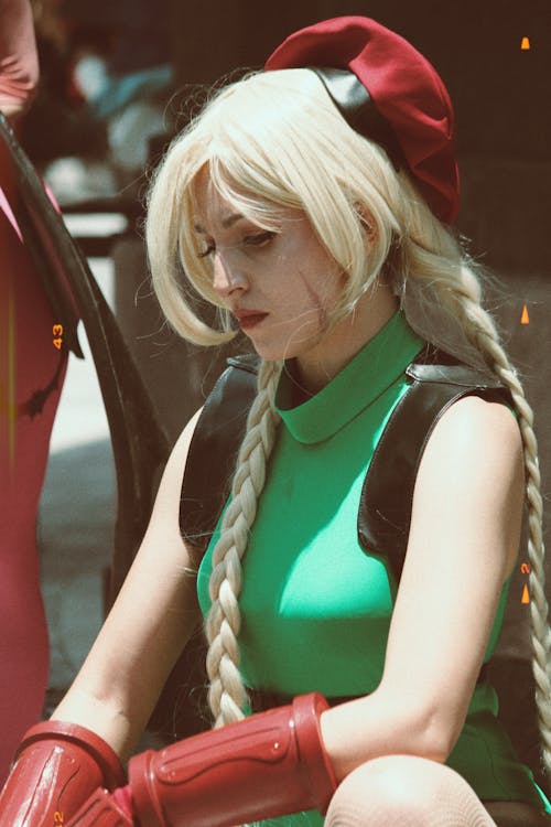 Woman in Green Street Fighter Costume Looking Down