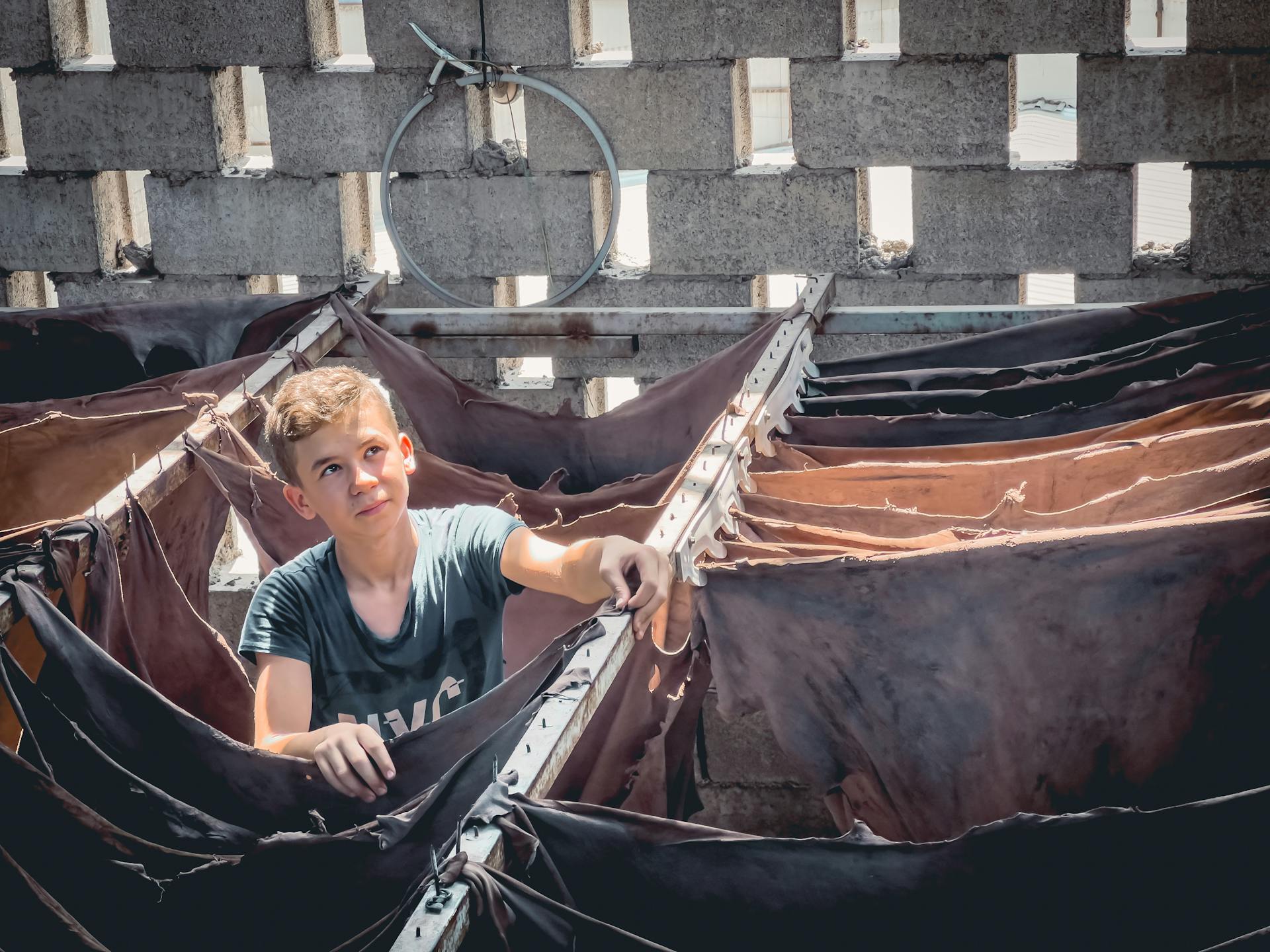 Teenage Boy Standing Among Drying Skins