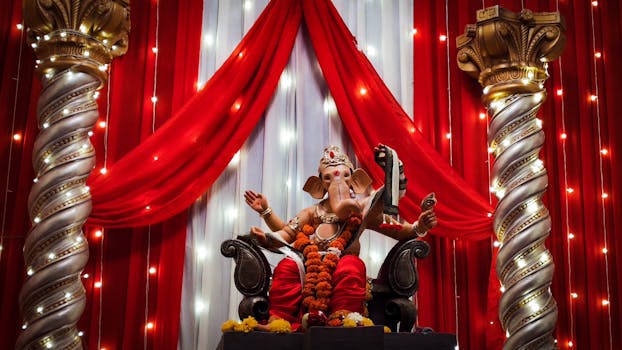 Vibrant Ganesha festival setup with ornate statue and festive lights.