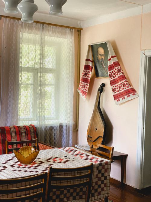 Free A warm dining area featuring a kobza, traditional textiles, and a vibrant vase on the table. Stock Photo