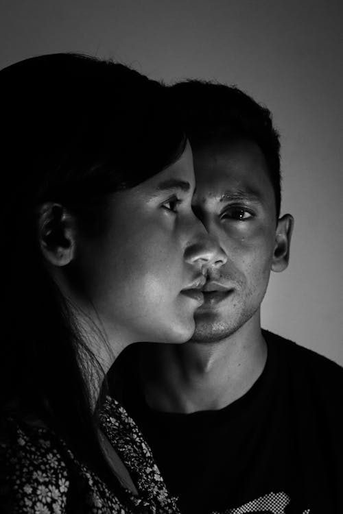 Man in Black Shirt Standing beside Woman in Black and White Floral Shirt