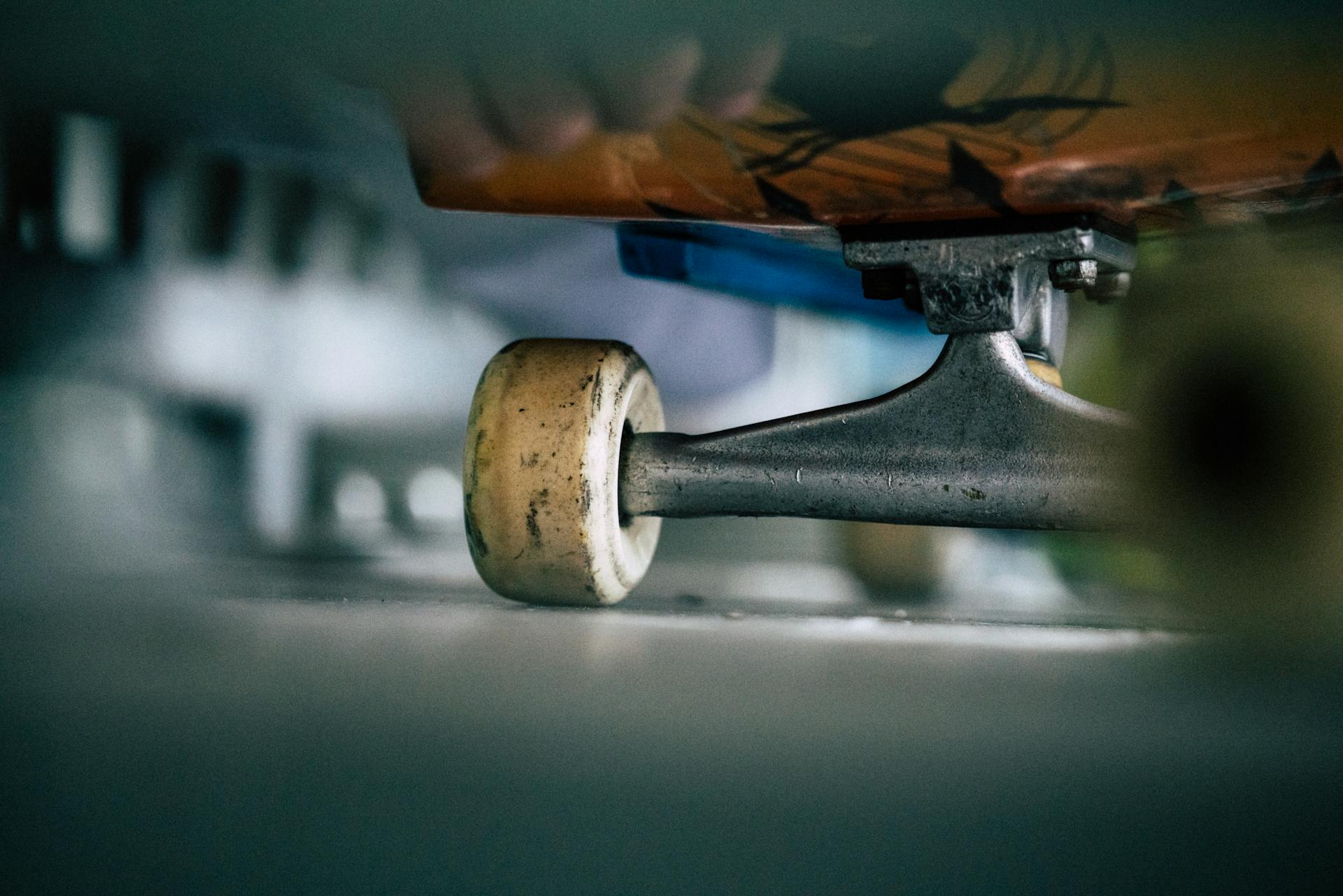 Detailed shot of a skateboard wheel and truck with selective focus outdoors.