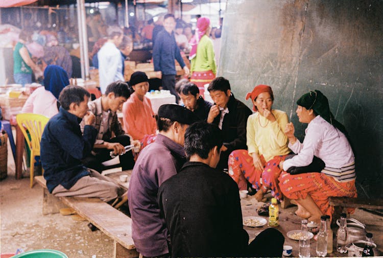 People Sitting On Brown Wooden Bench