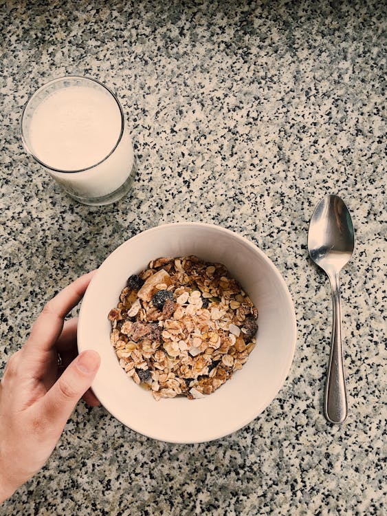 Round White Ceramic Bowl Filled With Oatmeal Beside Glass Of Milk