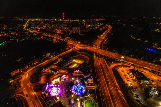 Stunning aerial view of a city at night with illuminated roads and vibrant nightlife below.