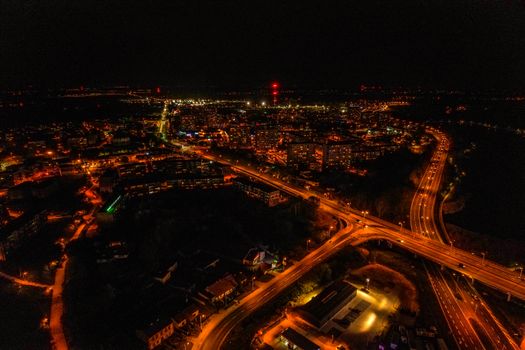 A breathtaking aerial view of a city illuminated at night, showcasing vibrant highways and infrastructure.