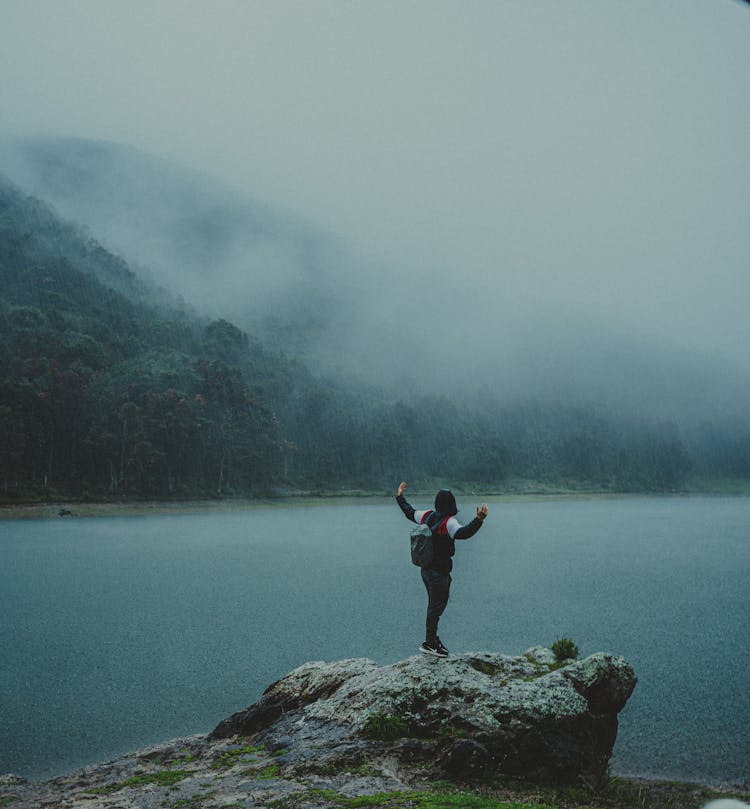 Hiker Standing On A Rock Near The Lake