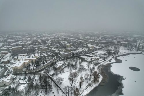 Free Aerial shot of a town covered with snow, featuring foggy skies and frozen lakes. Stock Photo