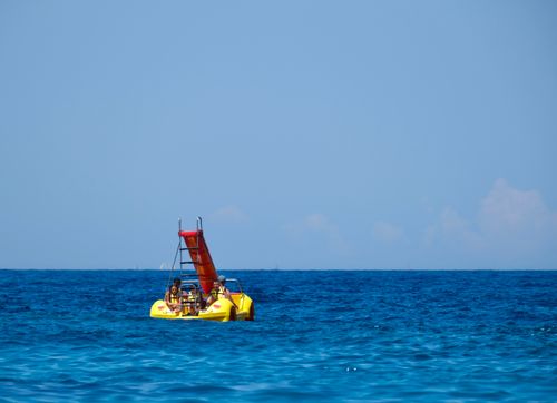 Free A colorful pedal boat with tourists enjoying a sunny summer day on Parga's azure waters. Stock Photo