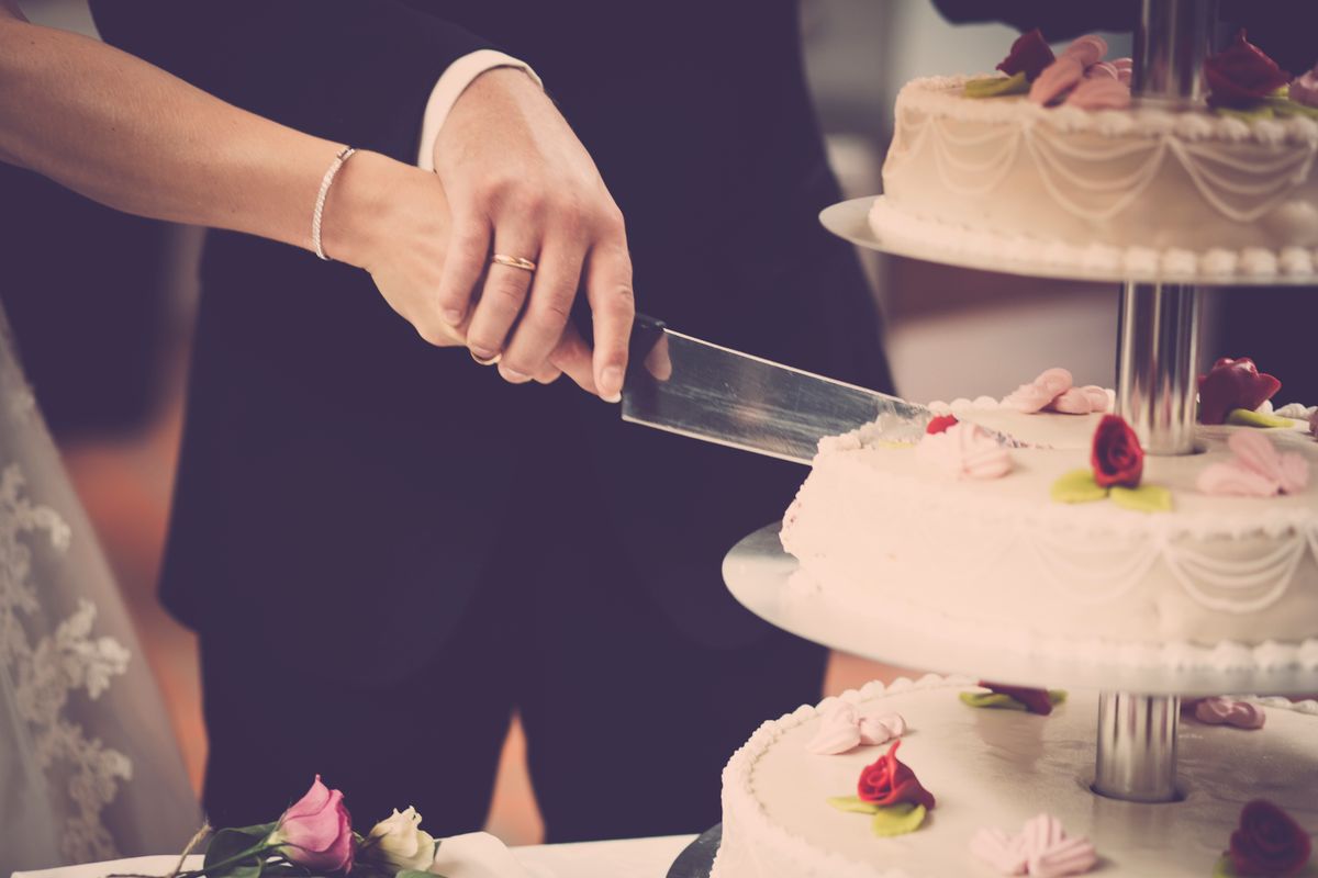 Bride and groom cutting a classic tiered wedding cake