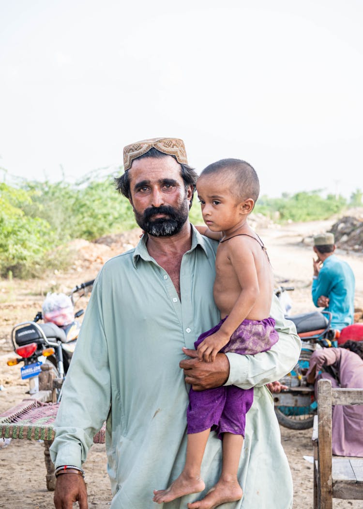 A Man Carrying A Young Boy