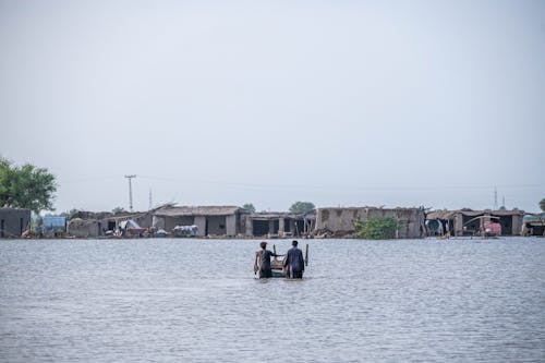 People Standing Knee Deep in Flood Water