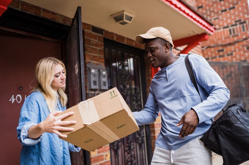 Courier handing a parcel to a customer at their doorstep