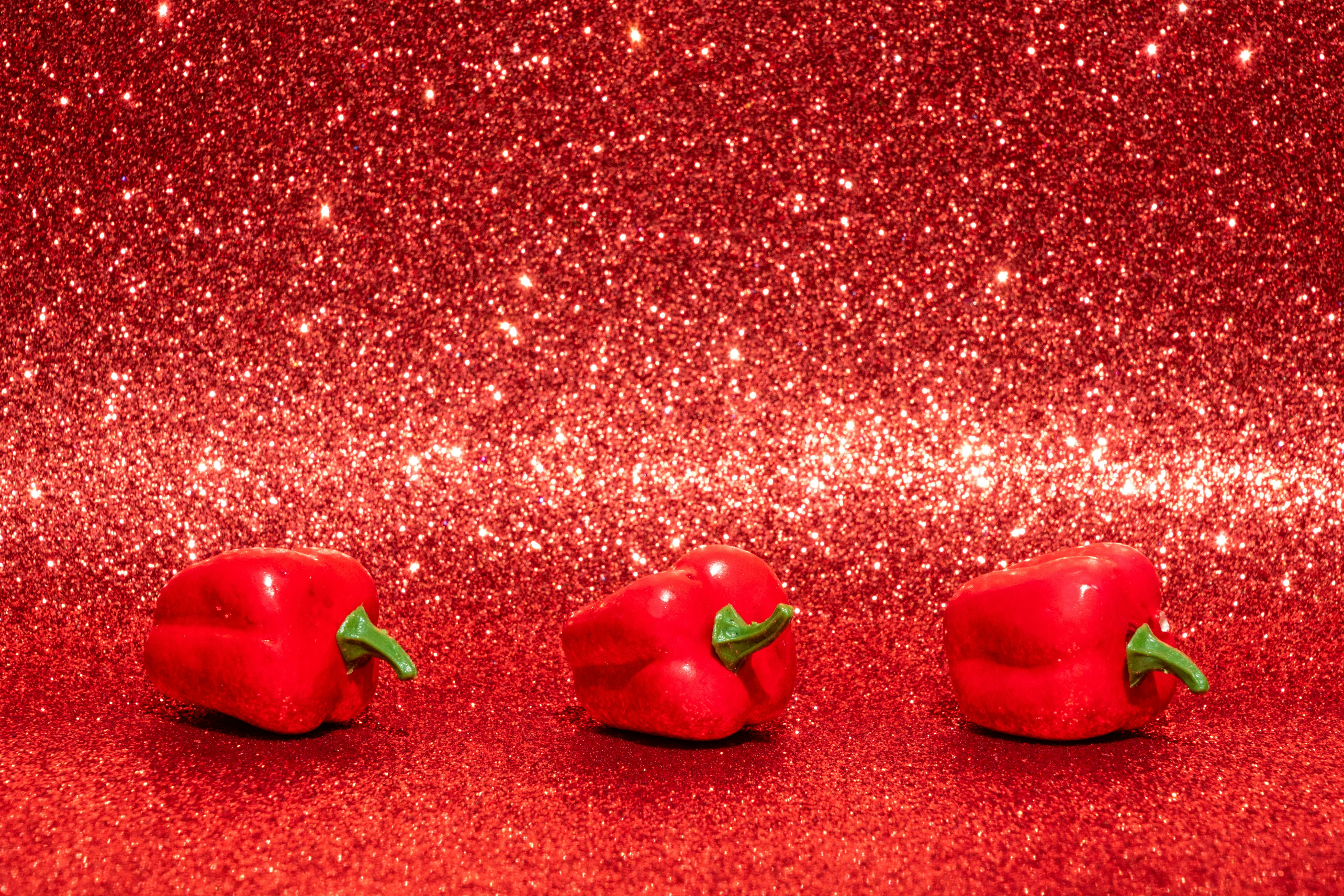 Three Red Bell Peppers on Red Surface