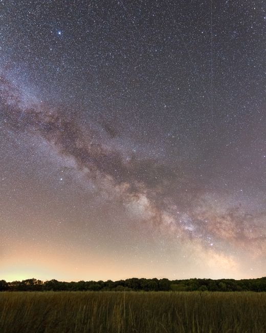 Beautiful Milky Way over a tranquil field in Fontainebleau, France at night.