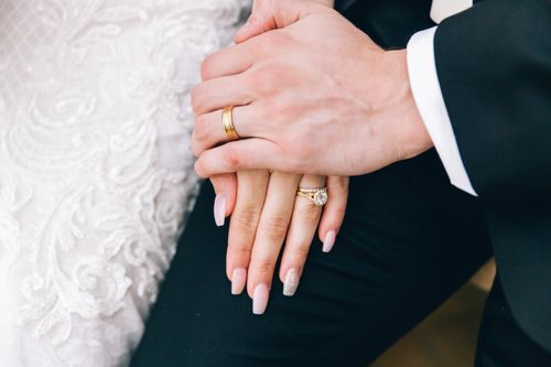 Free Close-up of a couple's hands during a wedding, showing elegant rings and bridal attire. Stock Photo